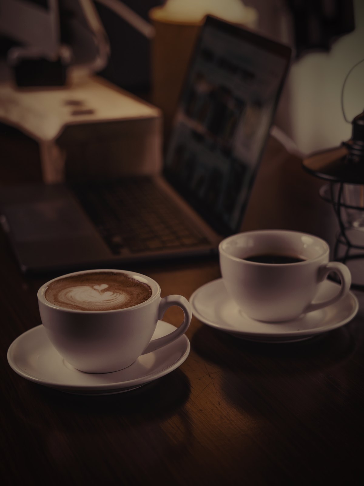 Two people either side of a small table with coffee, one sketching an interface on paper.